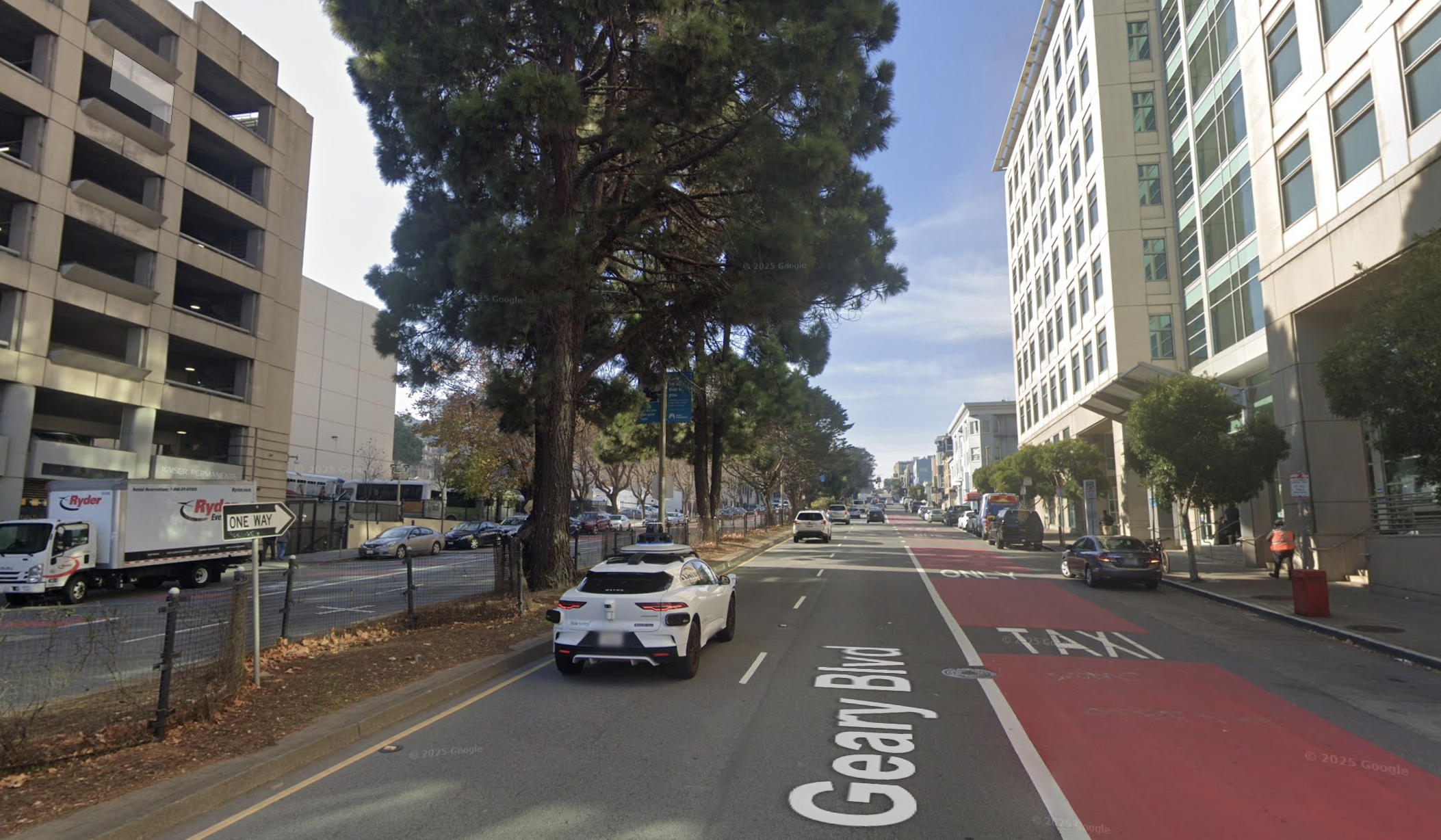 Same view in 2022 after BRT. A red-painted curb lane for buses on the right side. Median trees, street parking, and lane count all preserved.